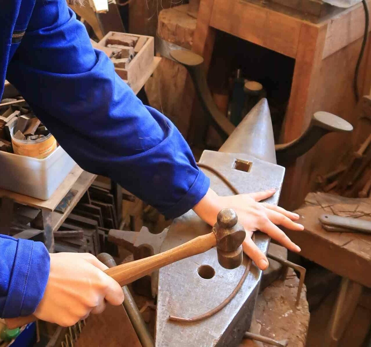 Une barre d'acier est façonnée au marteau sur une enclume